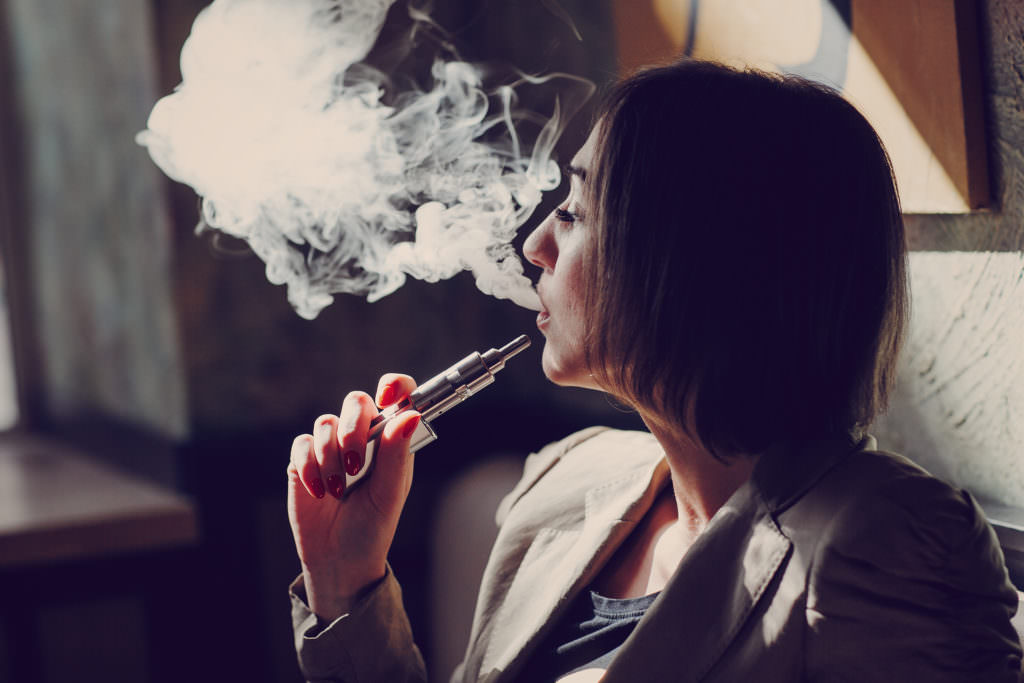 young woman smoking electronic cigarette